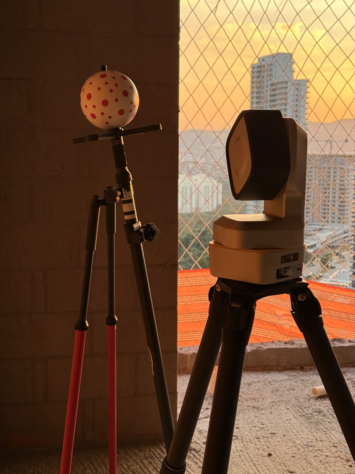 Estação total robótica e laser scanner no pavimento em obra ao pôr do sol